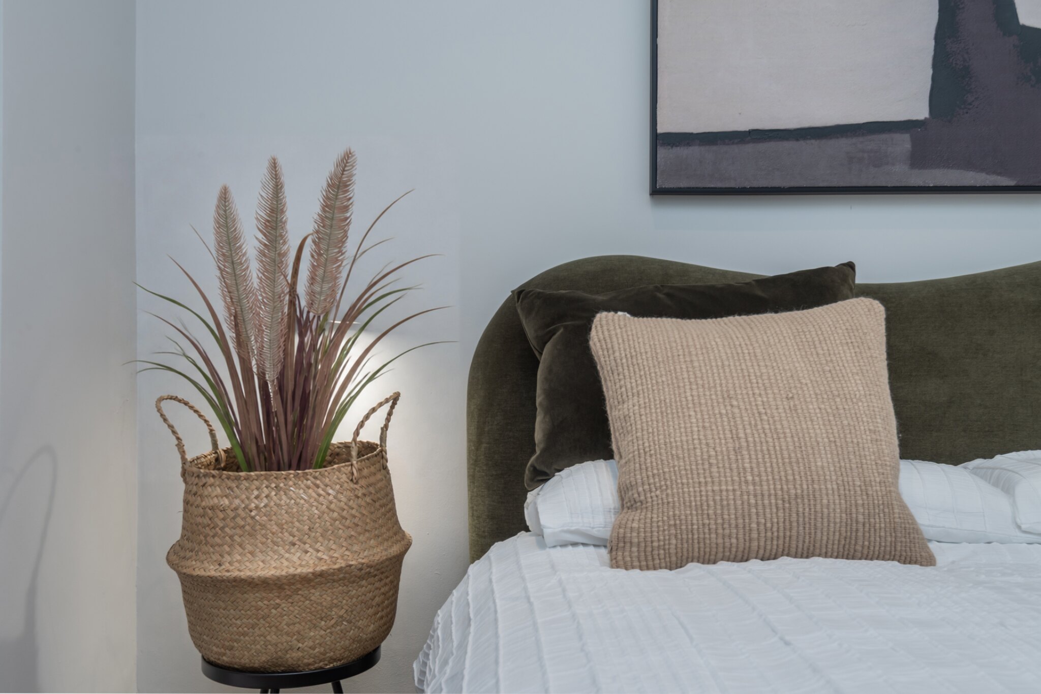 Portobello Road bedroom styling with woven planter and layered cushions